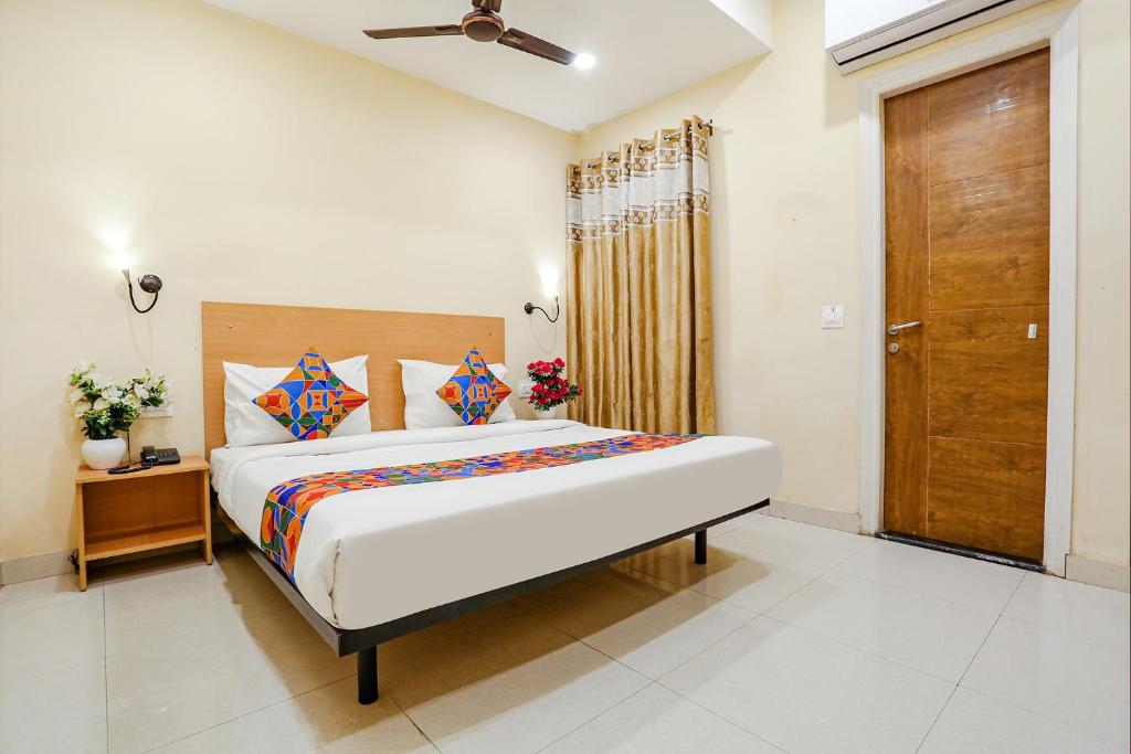 una camera con un grande letto e una porta in legno di FabHotel GK Residency a Nuova Delhi