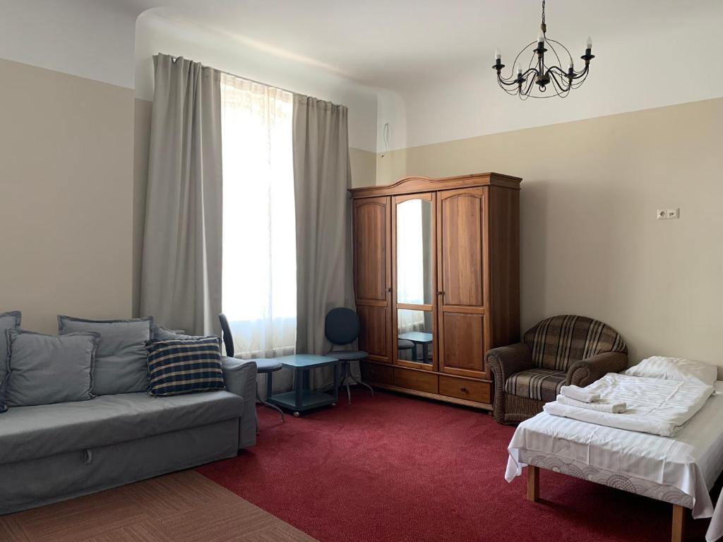 een woonkamer met een bank en een stoel bij Guesthouse Jakob Lenz in Rīga