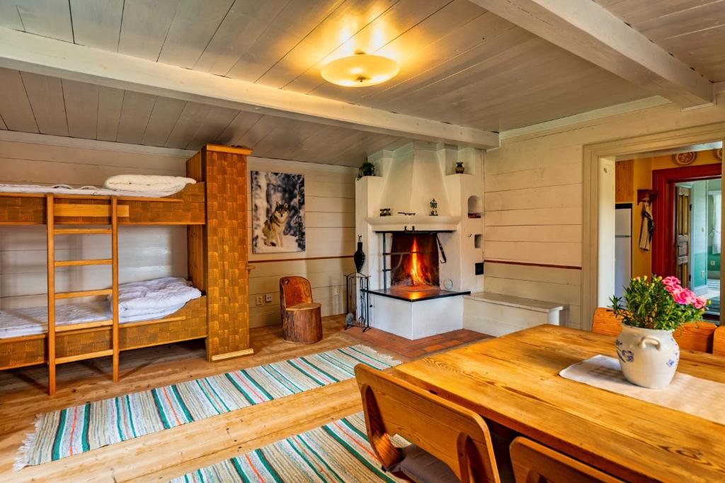 ein Wohnzimmer mit einem Tisch und einem Kamin in der Unterkunft Traditionell Timmerstuga - Mora, Gesunda in Sollerön