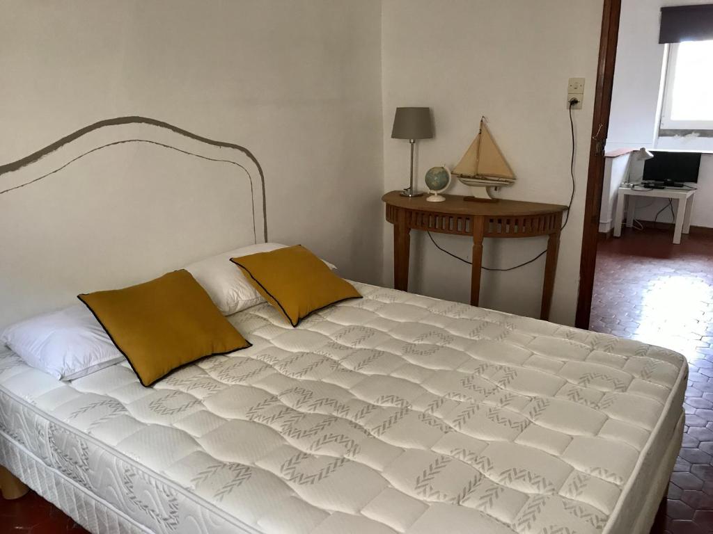 um quarto com uma grande cama branca e 2 almofadas em La Vigie em Antibes