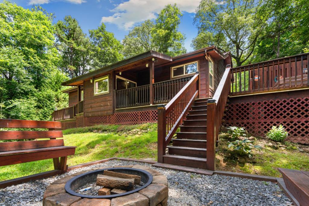 eine Blockhütte mit einer Treppe und einer Feuerstelle in der Unterkunft Peach Creek Lodge in Kiker