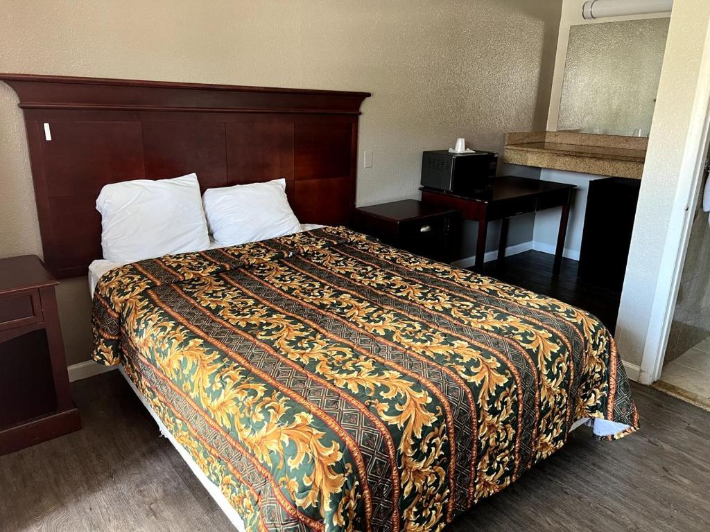 a hotel room with a bed and a desk at Budget Plaza Motel in Brooklyn Park