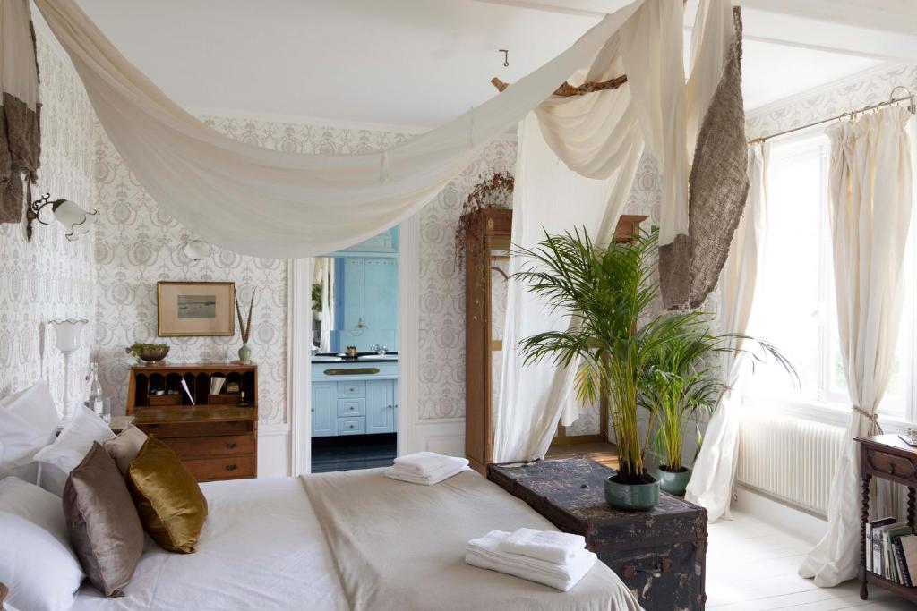 1 dormitorio con 1 cama grande con dosel en Chambre d’hôtes au Château Le Bas Bleu, Anaïs Nin, en Quesnoy-le-Montant