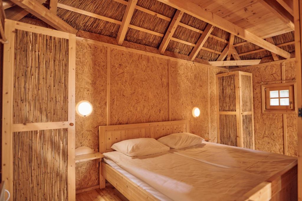 ein Schlafzimmer mit einem Bett in einem Zimmer mit Holzdecken in der Unterkunft Pirate Bay - Terme Čatež in Čatež ob Savi
