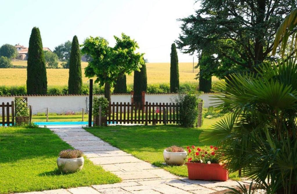 un giardino con recinzione e alcune piante di OASI DEL GARDA 2 a Monzambano