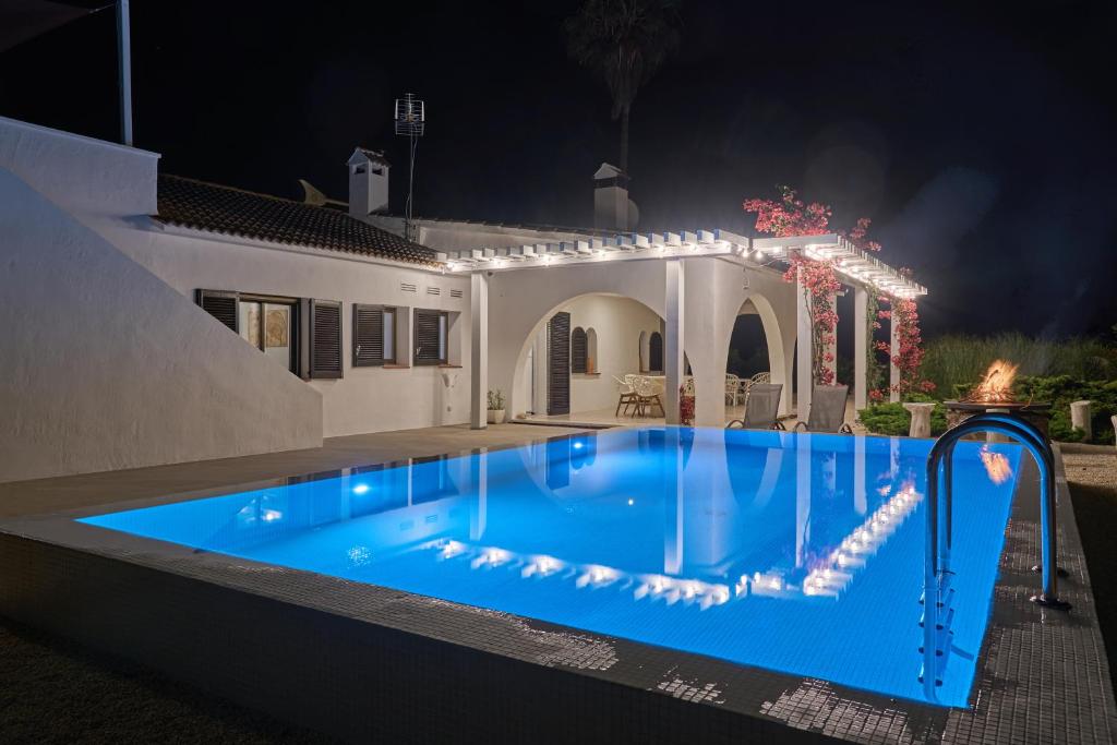 a swimming pool in front of a house at night at Casa Eucaliptus in L'Eucaliptus