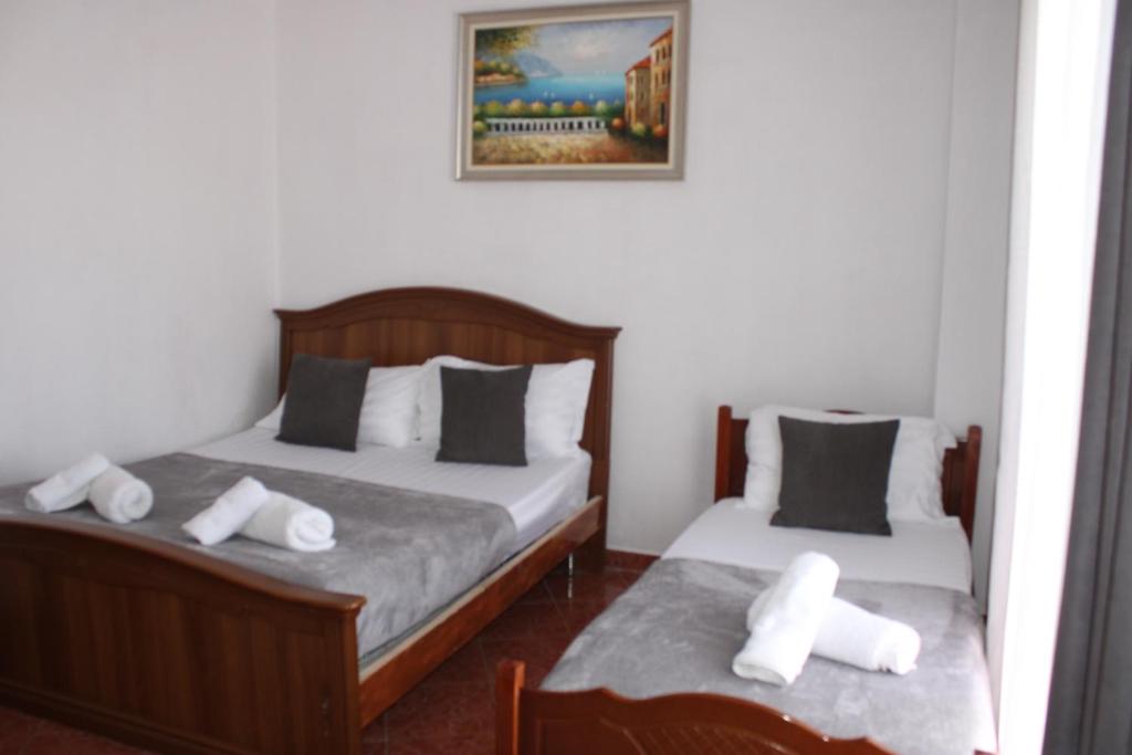 a bedroom with two beds with white pillows at Deni Family Apartament in Tirana