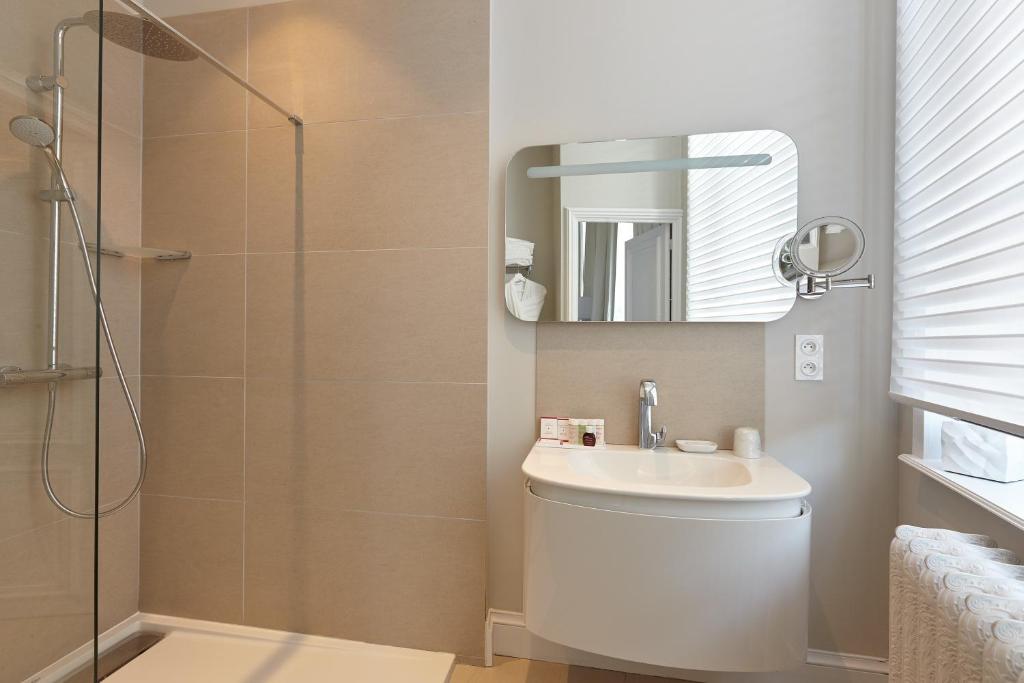 a bathroom with a toilet and a sink and a shower at Clarance Hotel Lille in Lille