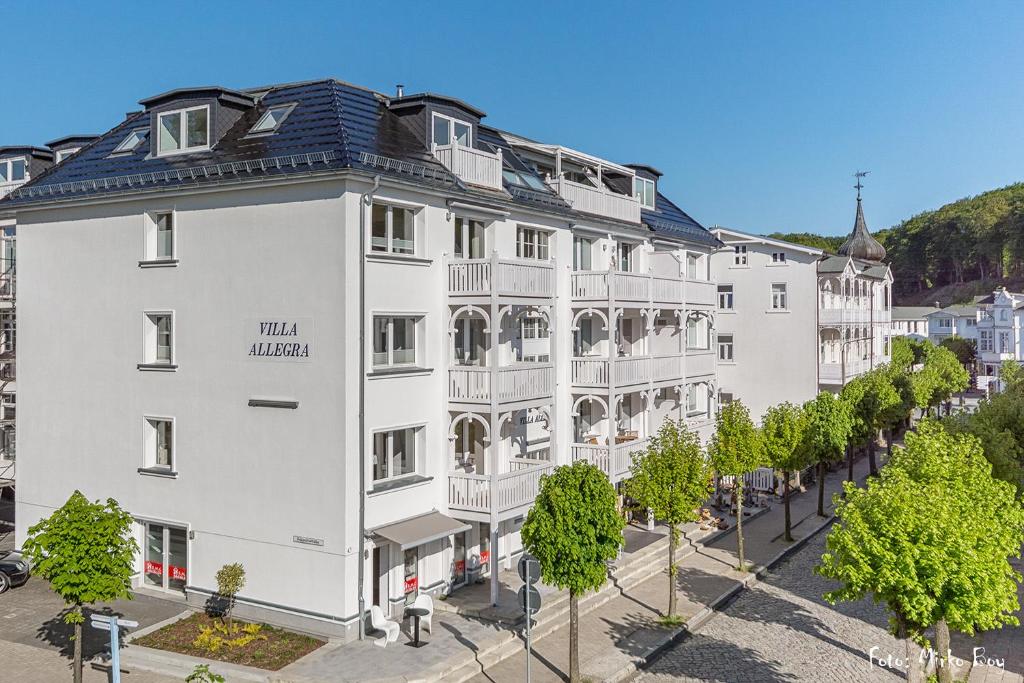 un grand bâtiment blanc avec des arbres devant lui dans l'établissement Villa Allegra, à Binz