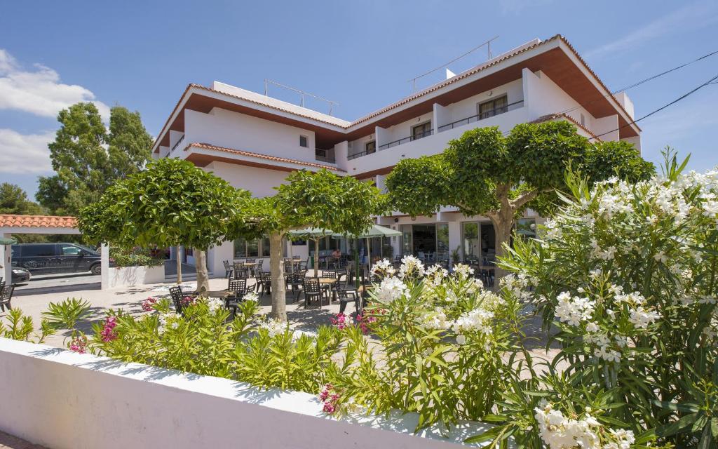 a house with trees and flowers in front of it at Hotel Bahia Playa in San Antonio Bay