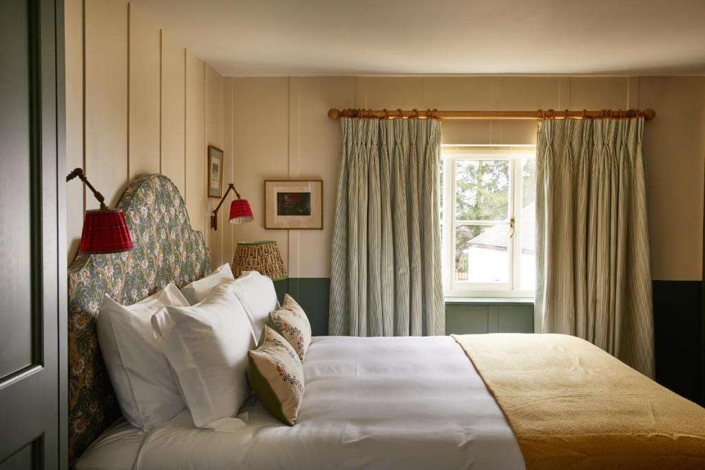 a bedroom with a white bed and a window at The Bear Inn, Hodnet in Market Drayton
