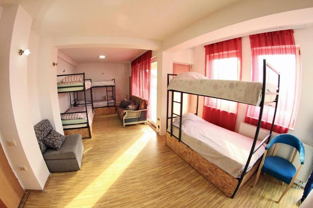 een kamer met 2 stapelbedden en een stoel bij Golden Age Hostel in Ohrid