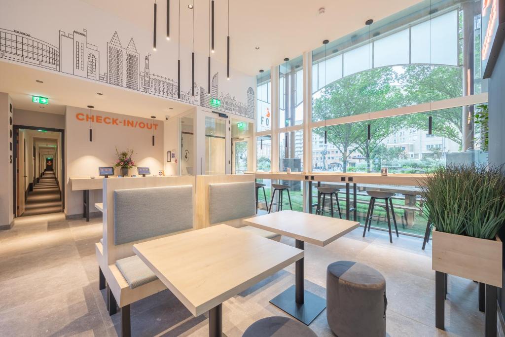 a restaurant with tables and chairs in a building at Fox Hotel The Hague Scheveningen in Scheveningen