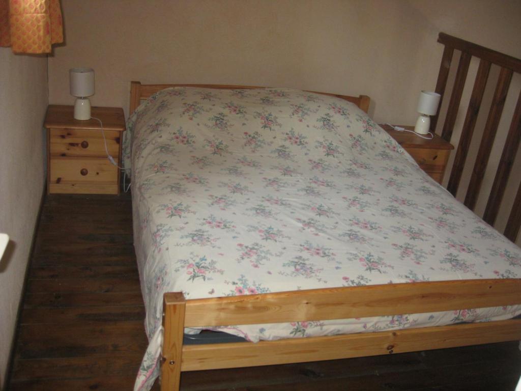 1 Schlafzimmer mit einem Bett mit Blumenbettdecke in der Unterkunft Gîte Mas des cabanes in Aimargues