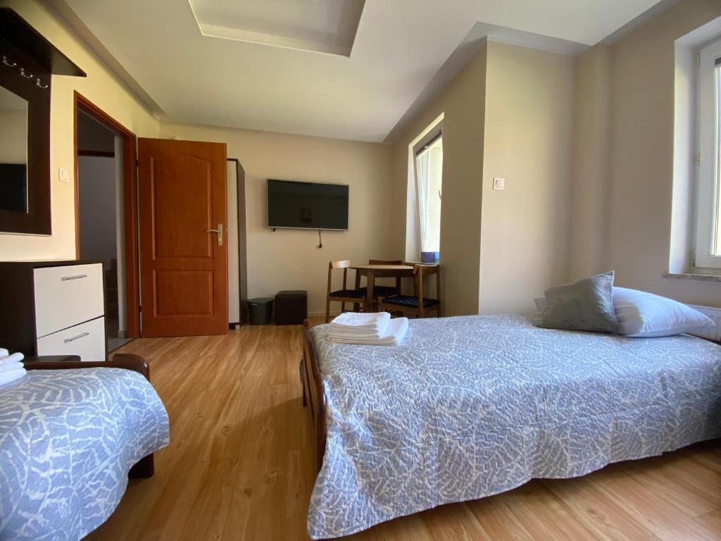 a bedroom with two beds and a tv on the wall at Dolores in Giżycko