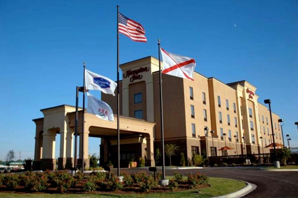 een gebouw met drie vlaggen ervoor bij Hampton Inn Calera in Calera