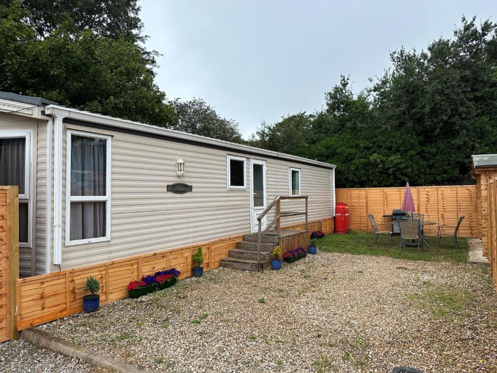 a mobile home with a fence and a patio at Static Caravan - Plymouth - Costal Location in Plymouth