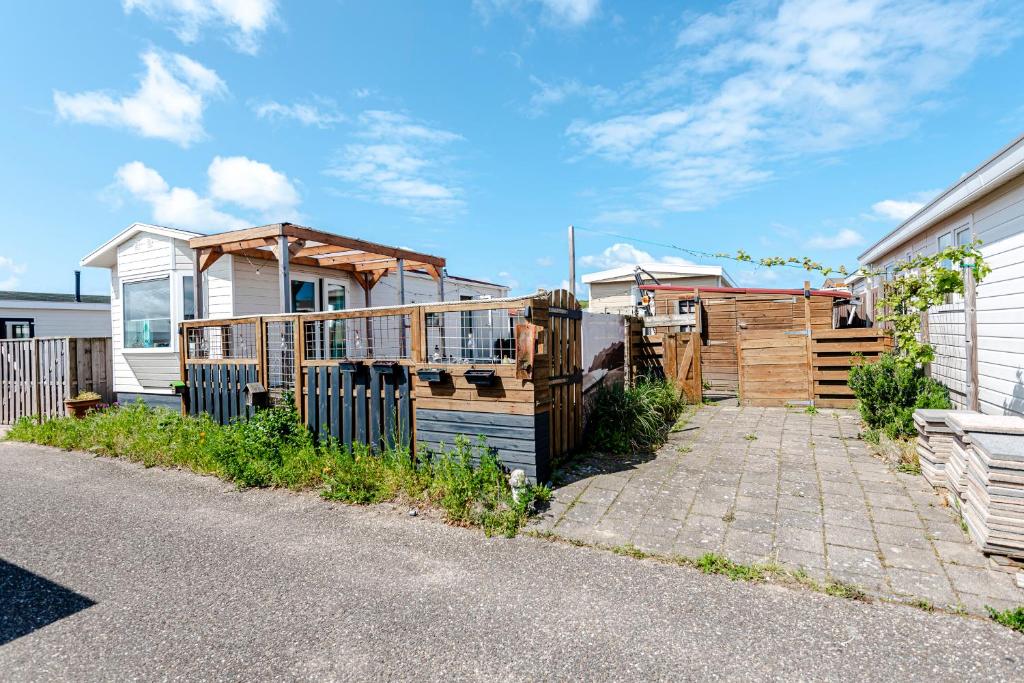 una casa con una recinzione di legno di fronte ad essa di The Happy Hippy a Zandvoort