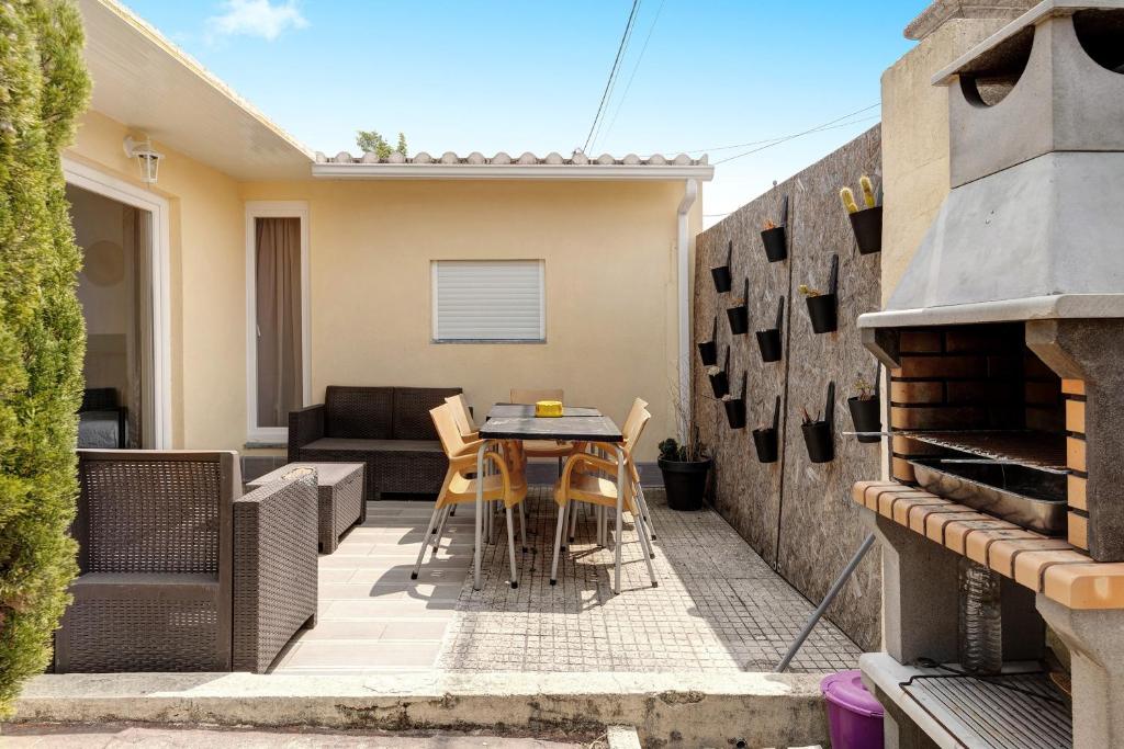 een patio met een tafel en stoelen en een bank bij Zen Village Azul in Fernao Ferro