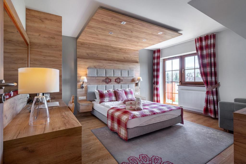 1 dormitorio con 1 cama en una habitación con paredes de madera en Parzenica B&B, en Białka Tatrzanska