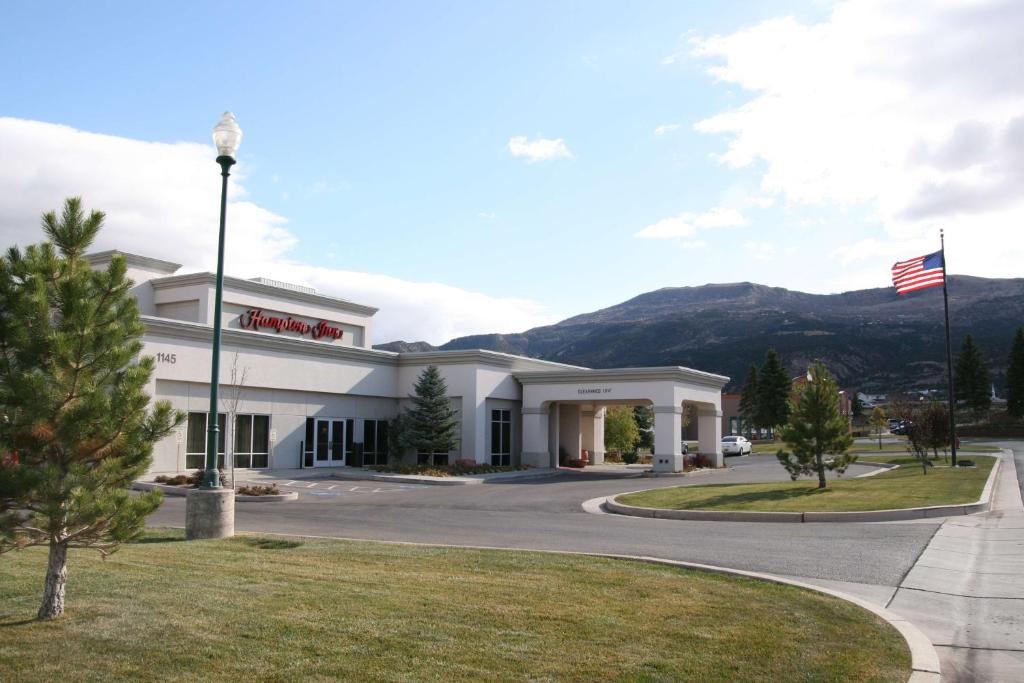 a building with an american flag in front of it at Hampton Inn Cedar City in Cedar City