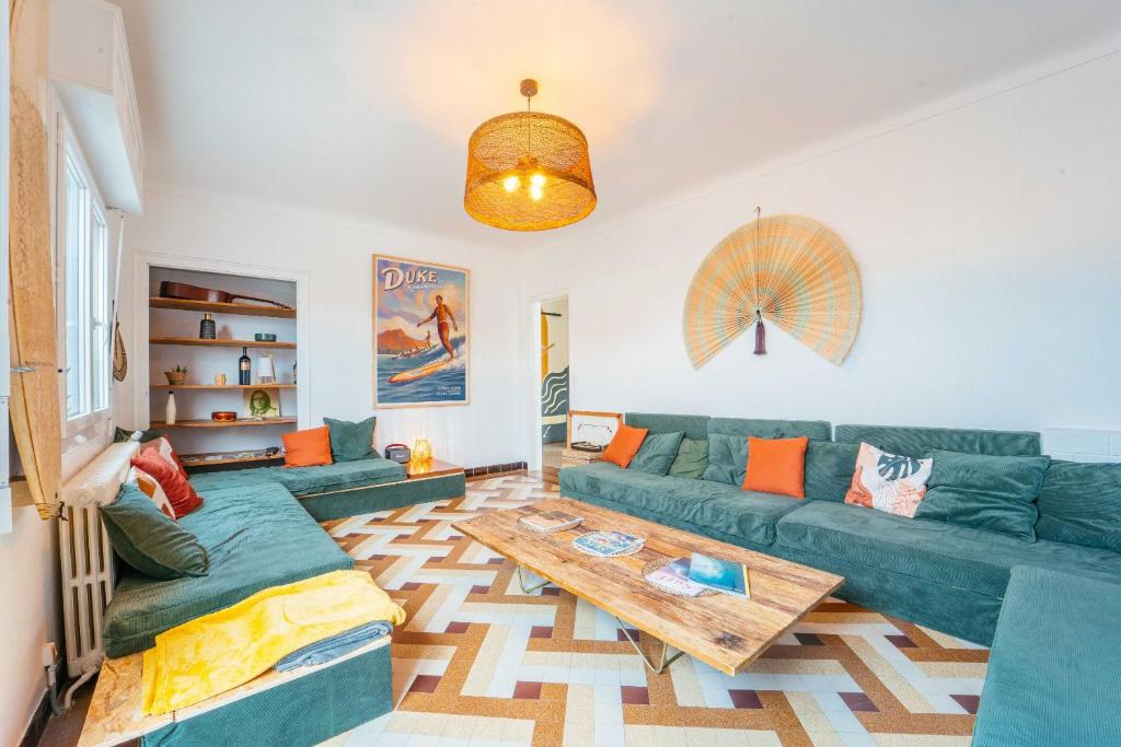 uma sala de estar com um sofá verde e uma mesa em La Boga L'Auberge à l'ambiance Surf à Biscarrosse Plage em Biscarrosse-Plage