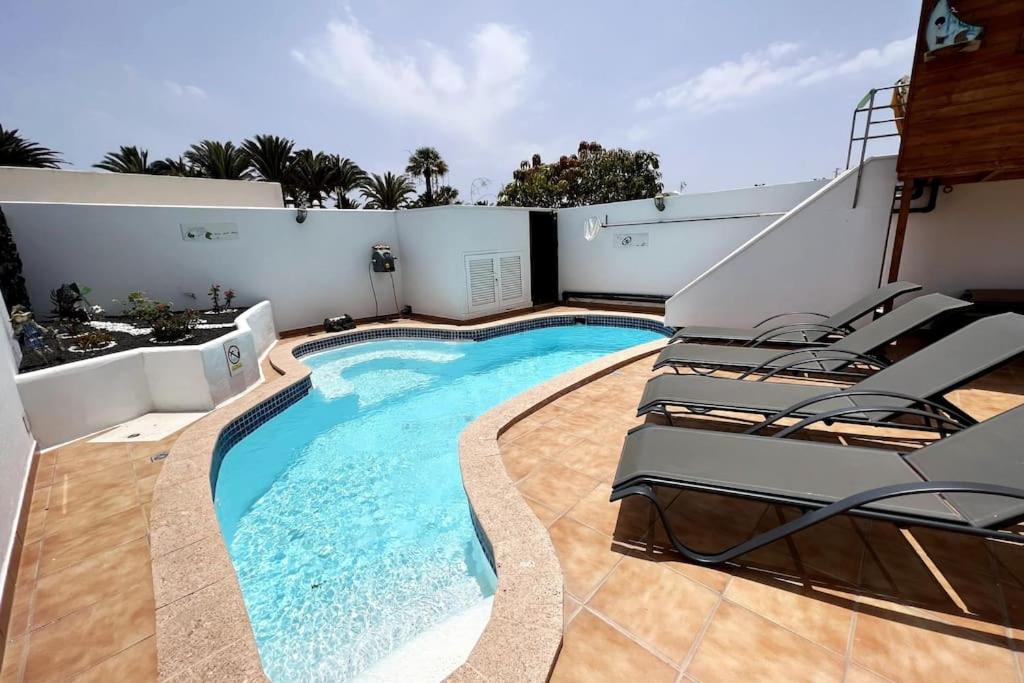 The Sallies - 3 bedroom villa with private pool في تياس: مسبح مع كراسي جلوس بجانب مبنى