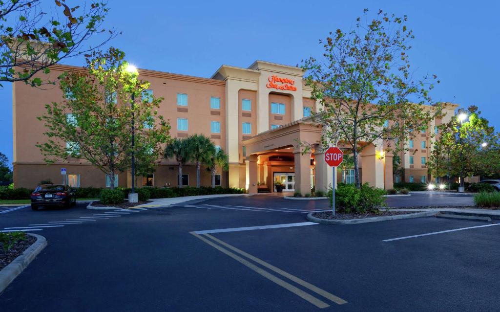 um hotel com um sinal de stop num parque de estacionamento em Hampton Inn & Suites Port Richey em Port Richey