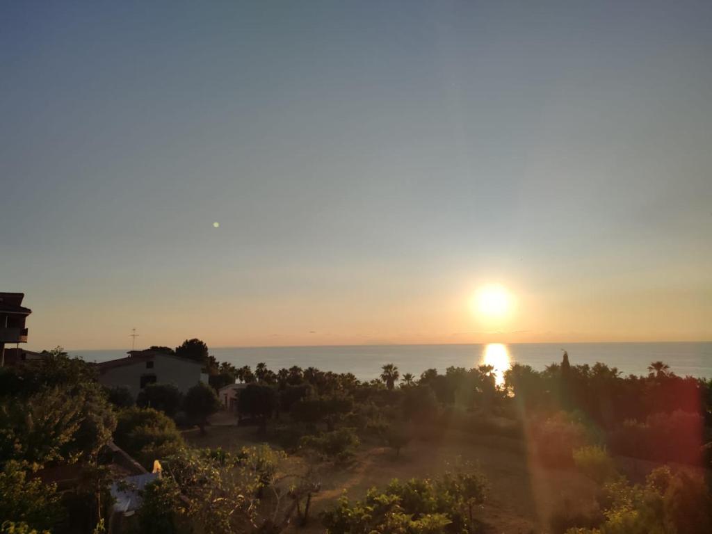 einen Sonnenuntergang über dem Meer von einem Haus in der Unterkunft Tramonto Apartment Seaview in Santa Domenica