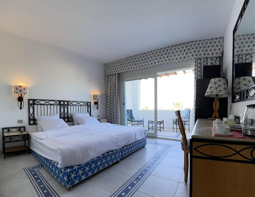 Azure Retreat - Private Luxury Sea View Apartment في شرم الشيخ: غرفة نوم بسرير ومكتب ونافذة