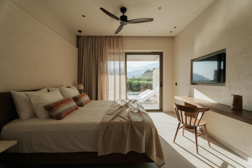 a bedroom with a bed with a ceiling fan at AMÉNTE Mindful Stay in Plakias