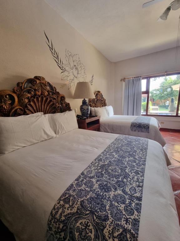 Postel nebo postele na pokoji v ubytování Hacienda de las Flores