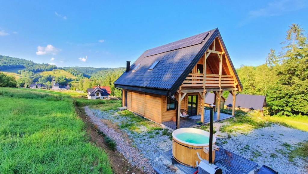 a log cabin with a hot tub in front of it at Górska Ostoja in Sieniawa