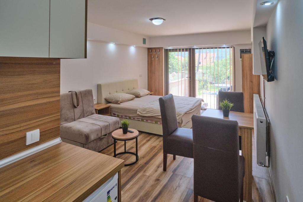 een kleine kamer met een bed en een bank bij Apartmani Tvins in Soko Banja