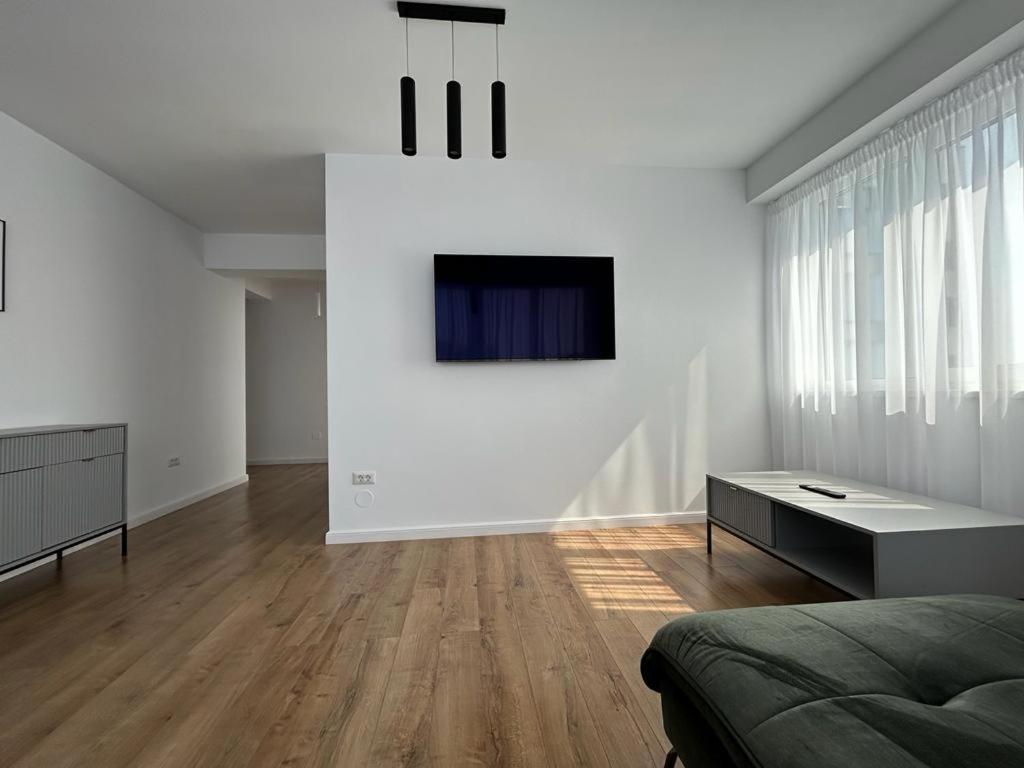 a white living room with a couch and a table at Lovely Cozy Apartments in Central Suceava in Suceava