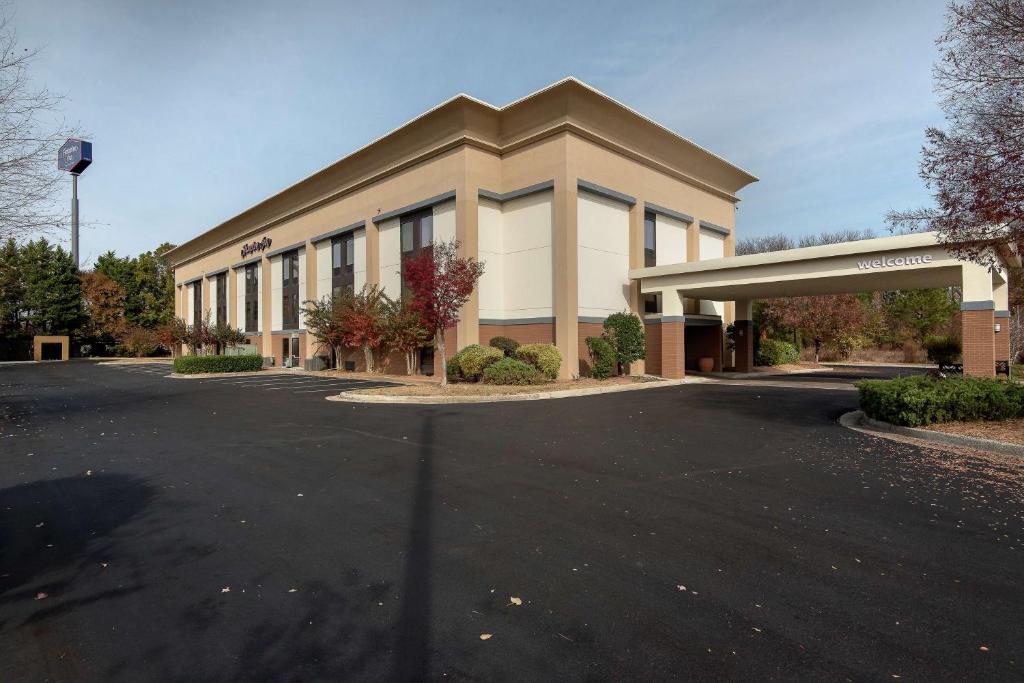 ein Gebäude mit einem davorliegenden Parkplatz in der Unterkunft Hampton Inn Commerce in Commerce