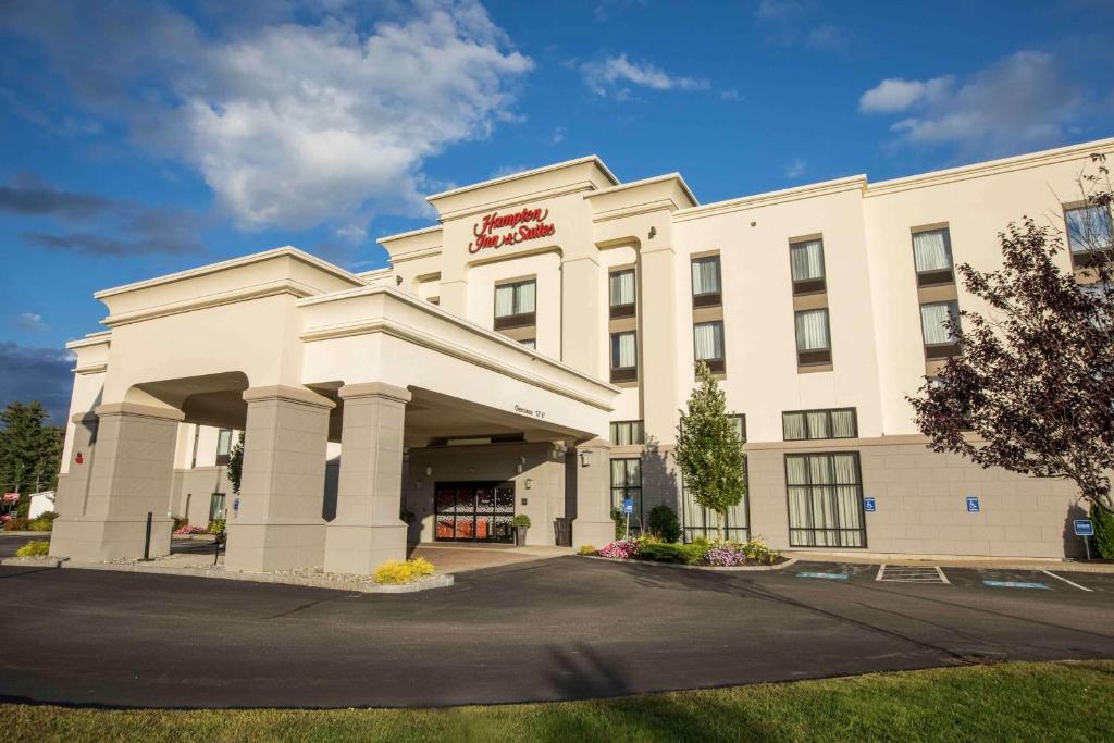 Ein weißes Gebäude mit einem roten Schild drauf. in der Unterkunft Hampton Inn & Suites Tilton in Tilton