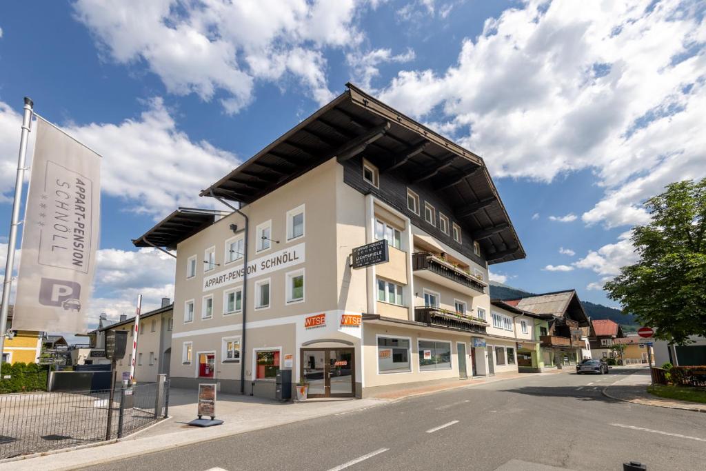 a large white building on the side of a street at Appart-Pension Schnöll in Mittersill