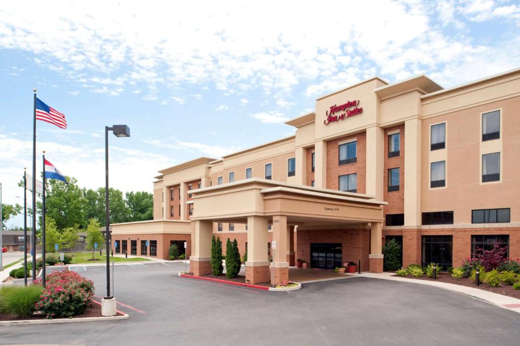 コロンビアにあるHampton Inn & Suites Columbia at the University of Missouriの駐車場のアメリカ旗を掲げるホテル