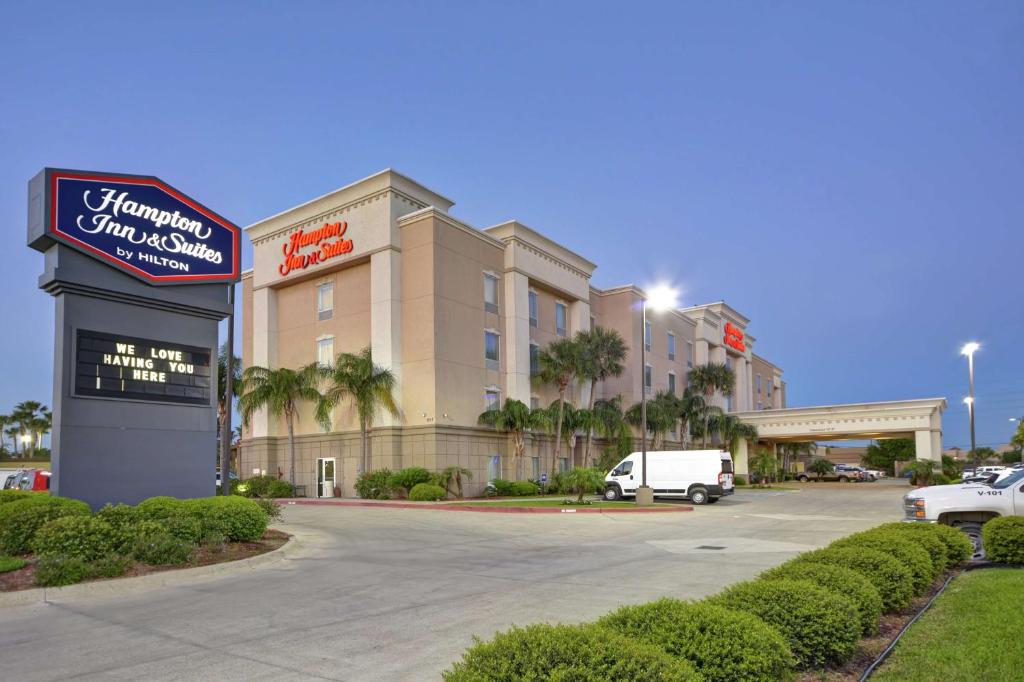 a hotel with a sign in front of a parking lot at Hampton Inn & Suites Corpus Christi I-37 - Navigation Boulevard in Corpus Christi