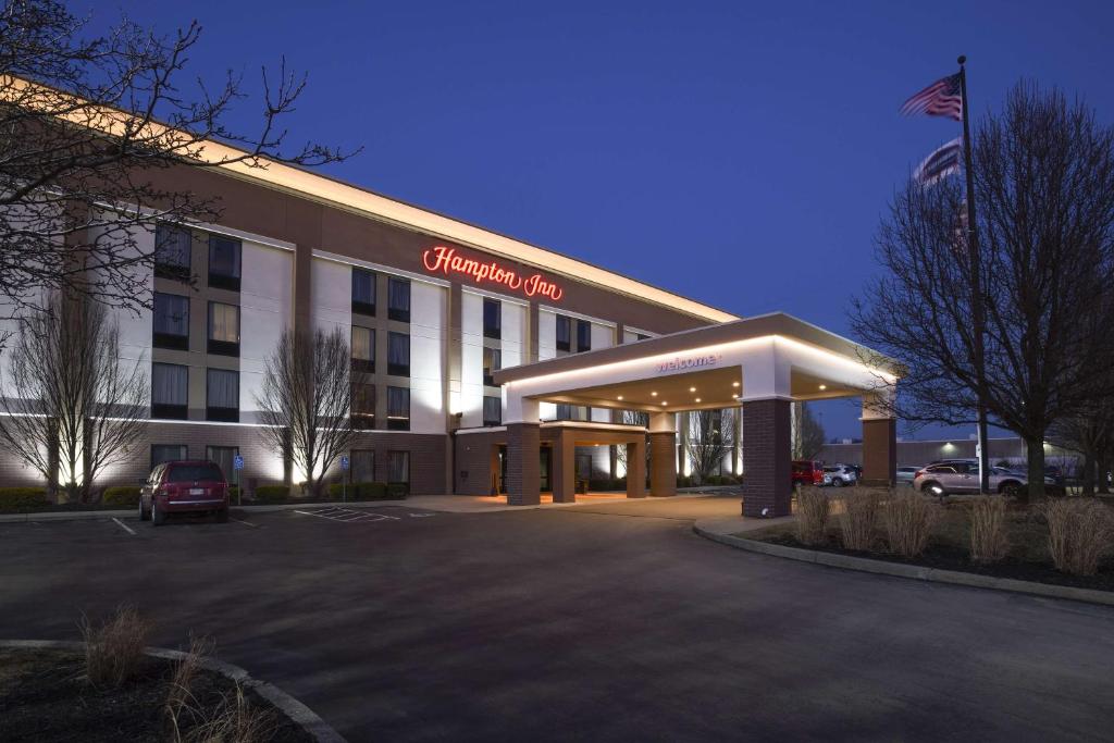 ein Hotelgebäude mit einem Auto auf einem Parkplatz in der Unterkunft Hampton Inn Cincinnati Eastgate in Eastgate