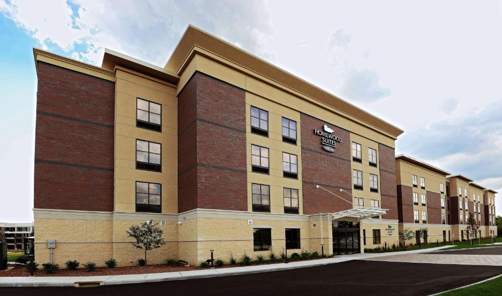 a large brick building with a sign on it at Homewood Suites by Hilton Cincinnati/Mason in Mason