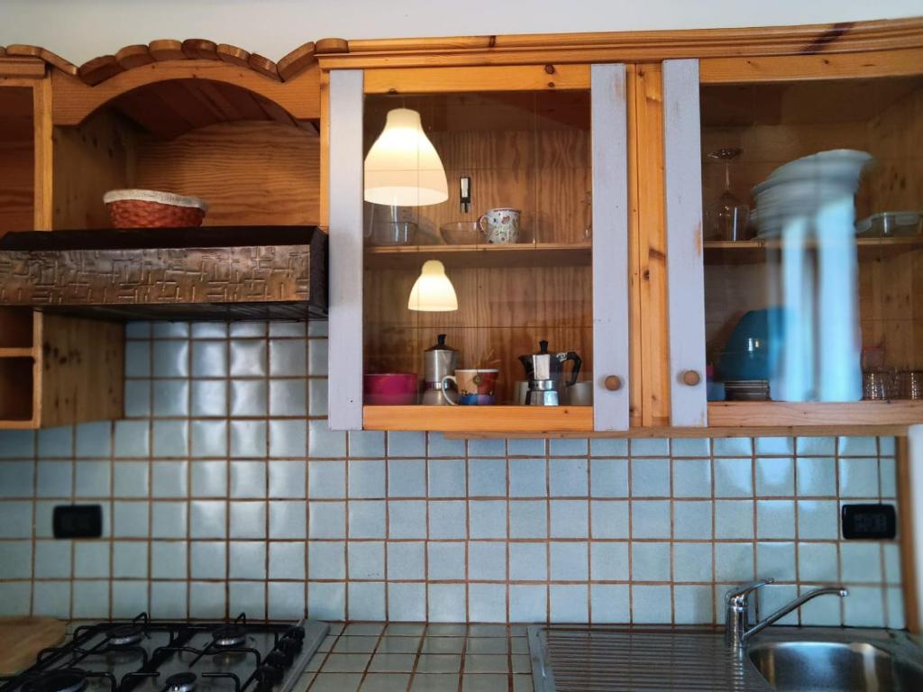 een keuken met houten kasten en tegels aan de muur bij OASI DEL GARDA 5 in Monzambano