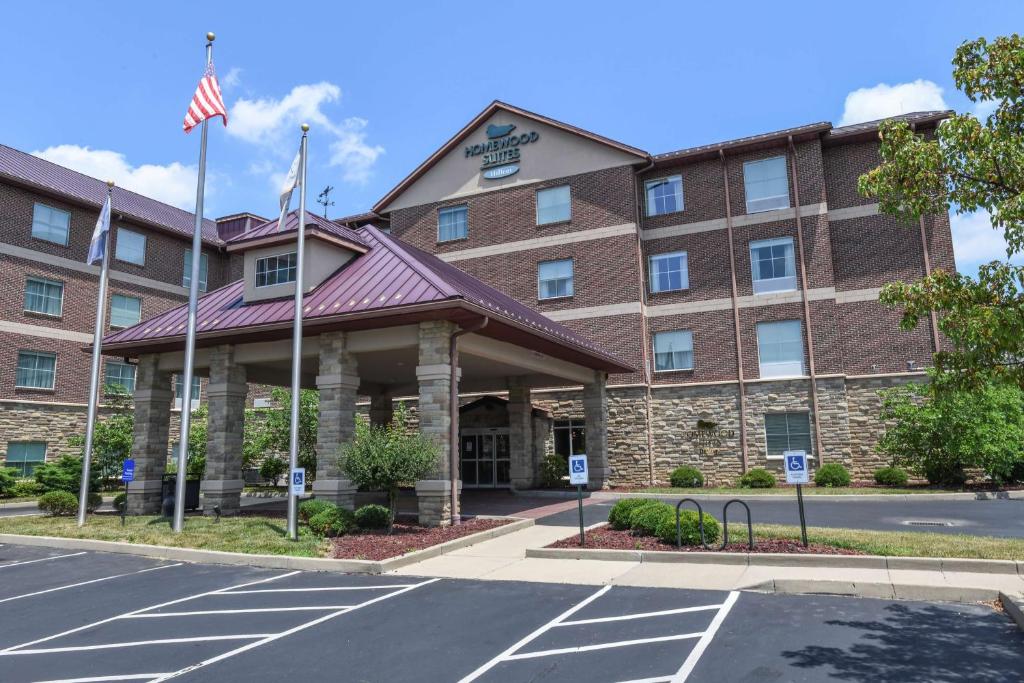 an exterior view of a hotel with an american flag at Homewood Suites Cincinnati Airport South-Florence in Florence