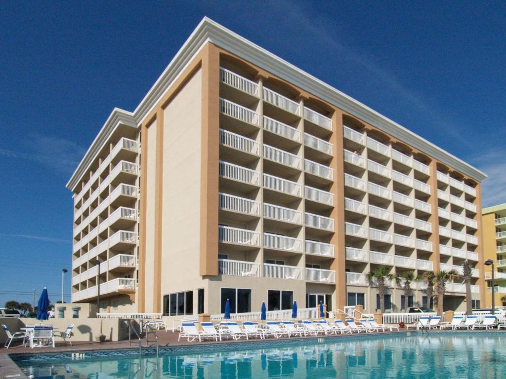 een groot gebouw met een zwembad ervoor bij Hampton Inn Daytona Shores-Oceanfront in Daytona Beach