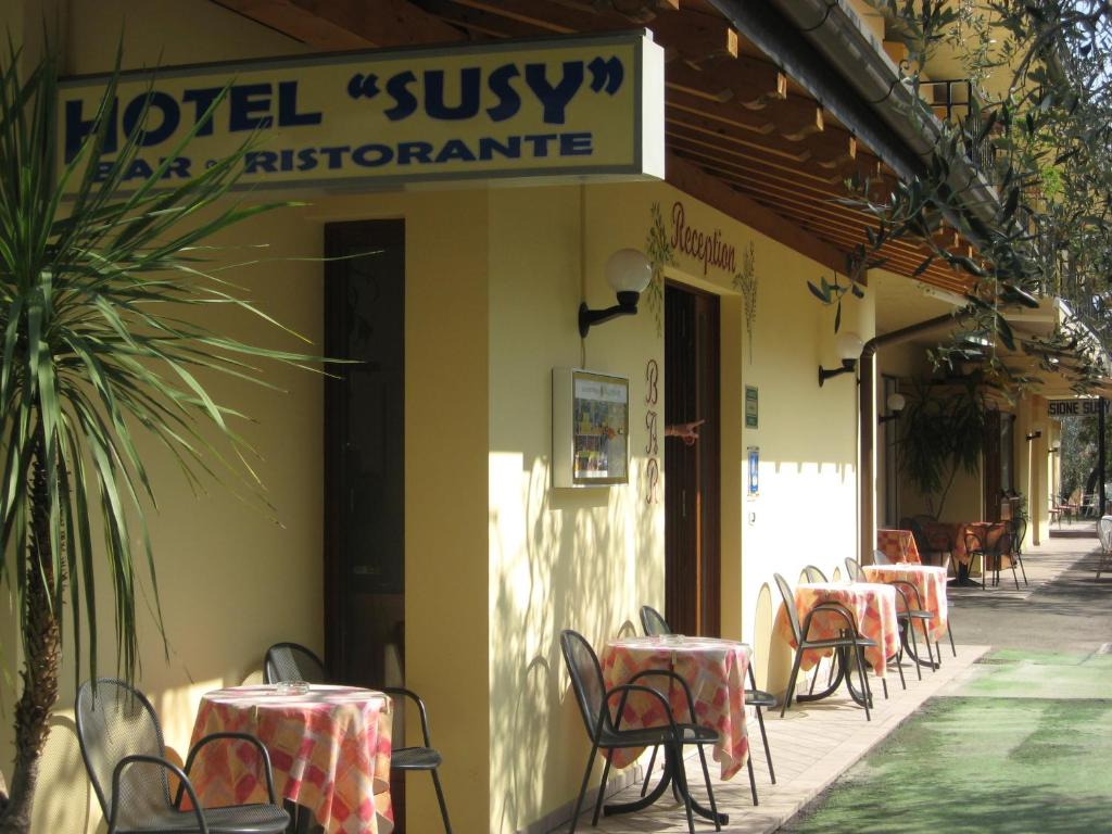 ein Restaurant mit Tischen und Stühlen auf einer Terrasse in der Unterkunft Hotel Susy in Limone sul Garda