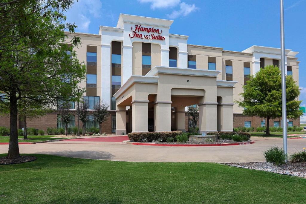 un edificio con un cartel en la parte delantera en Hampton Inn & Suites Dallas-DeSoto, en DeSoto
