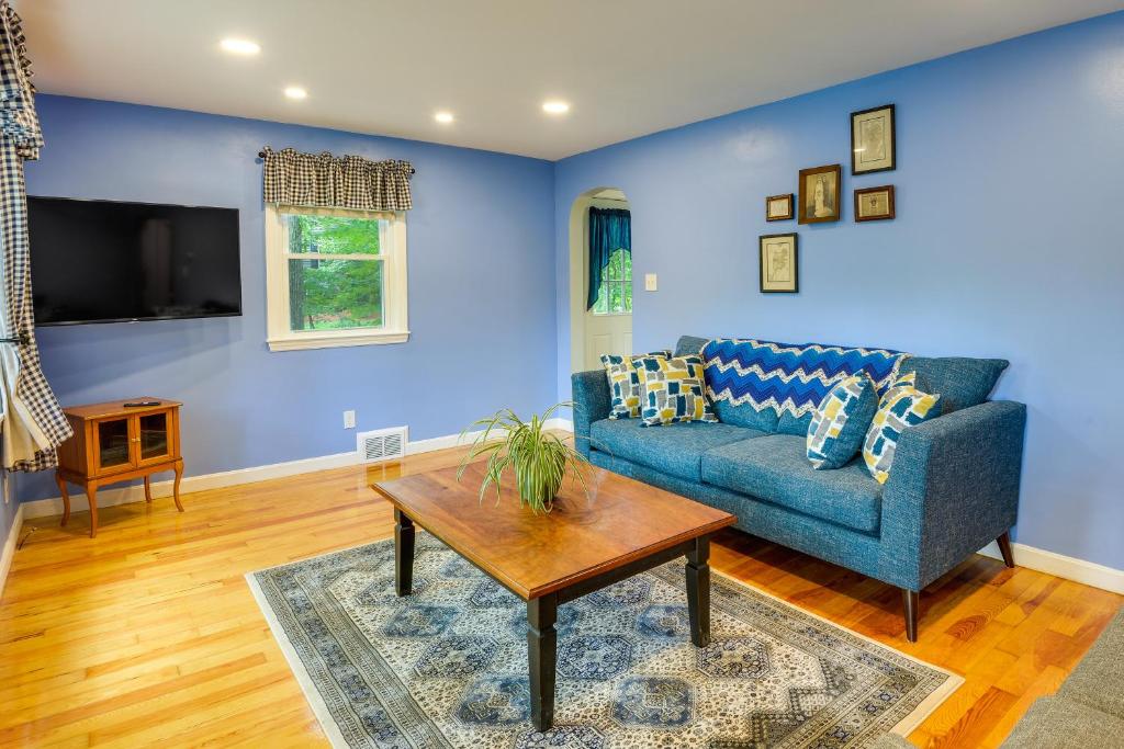 a living room with a blue couch and a table at Dog-Friendly Fitchburg Vacation Rental, Hike and Ski in Fitchburg