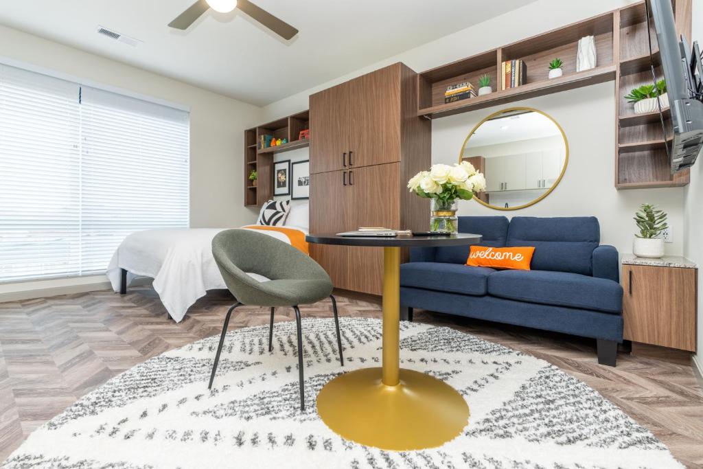 a living room with a blue couch and a mirror at Yugo Guest Suites in Urbana