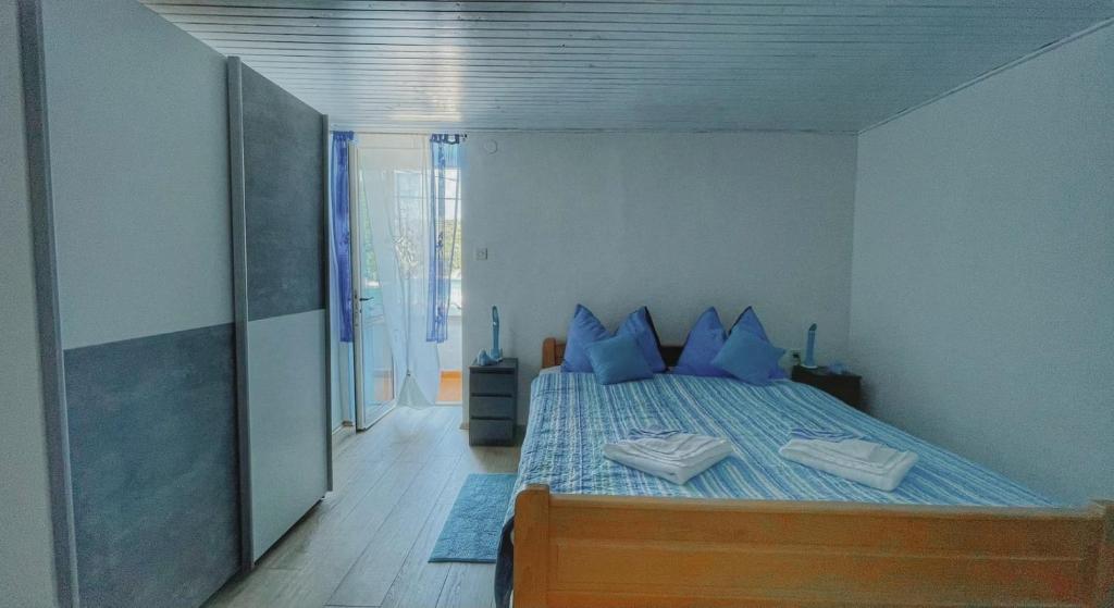 1 dormitorio con 1 cama con almohadas azules en Guesthouse Porto, en Cres